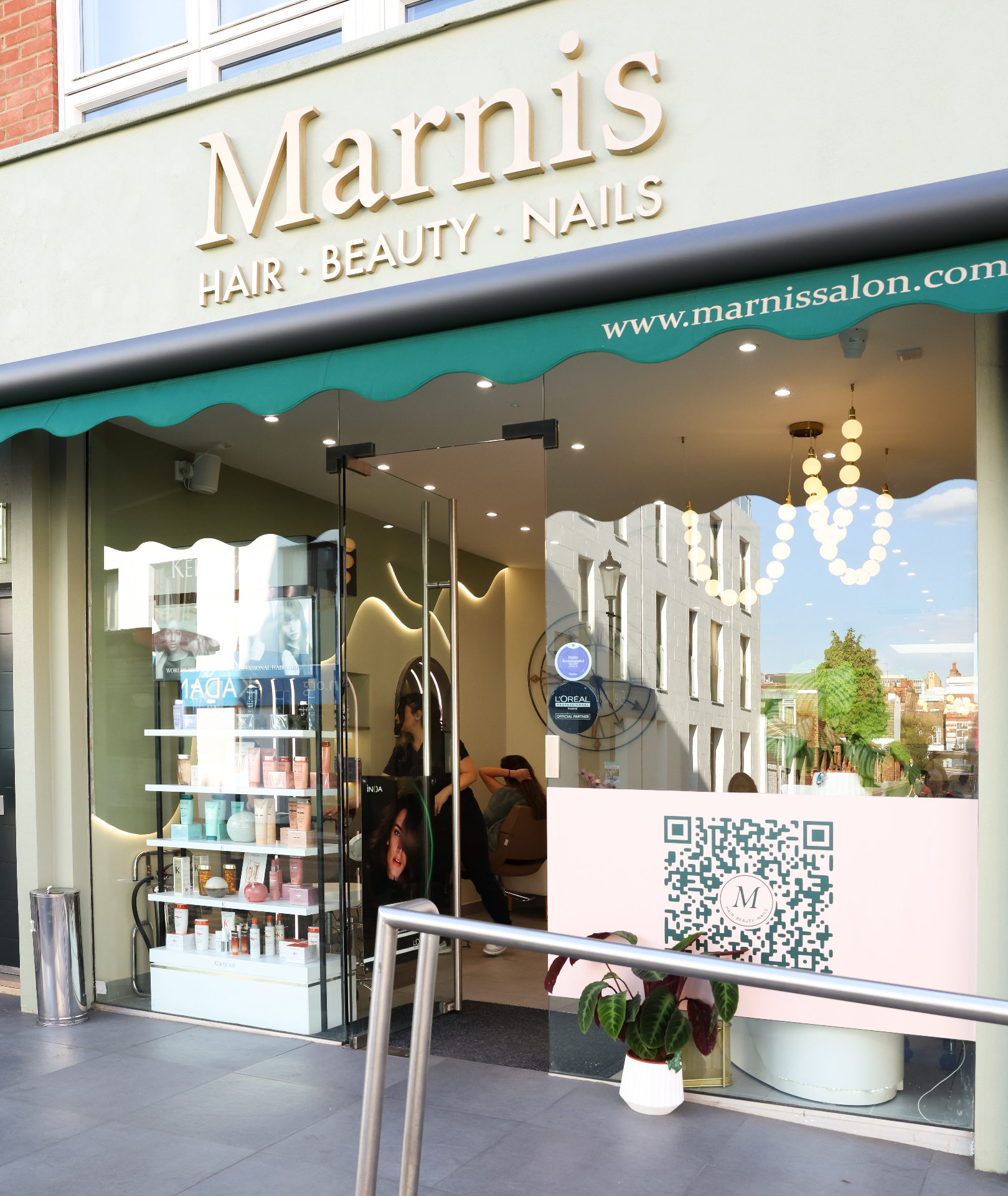 Marnis salon storefront on Earls Court Road , sage exterior with signature scalloped awning